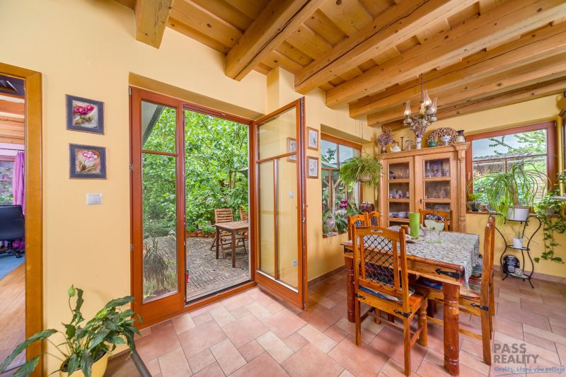 Dining in a family house with a table, plants, and a view of the terrace.