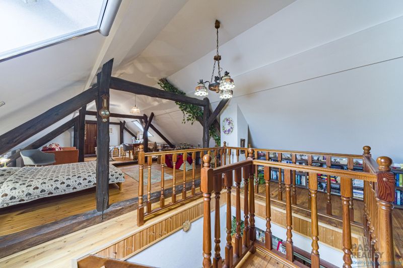 The attic of a family house with wooden railings, beams, and flooring with a wooden decor.