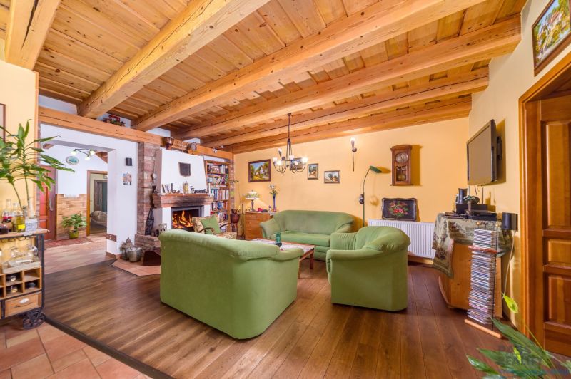 Living room in a family house with a wooden decor floor and a fireplace.