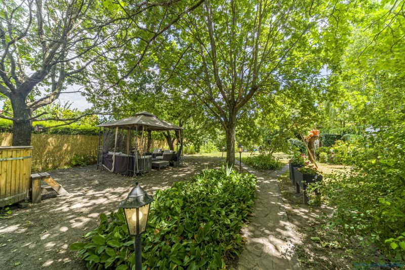 The garden of a family house on Čigérska Street in Dunajská Streda, gazebo, trees, floral decorations.