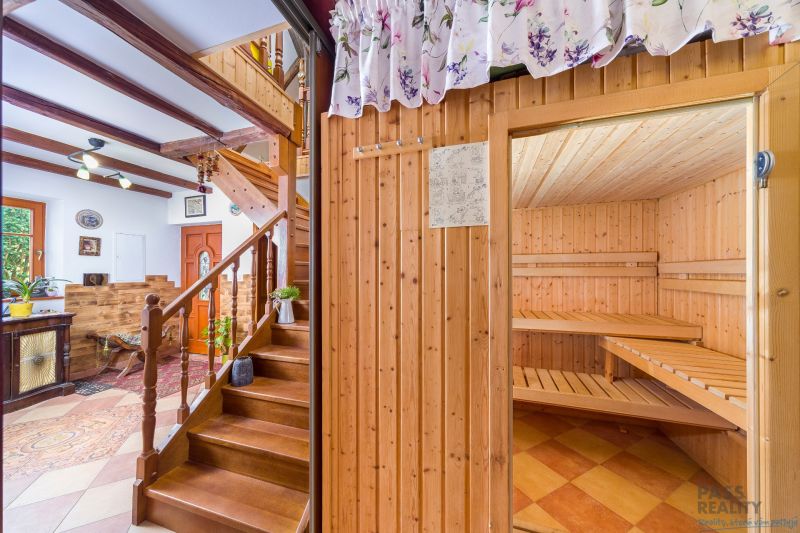 Interior of a family house with a staircase, wooden decor flooring, and a sauna.