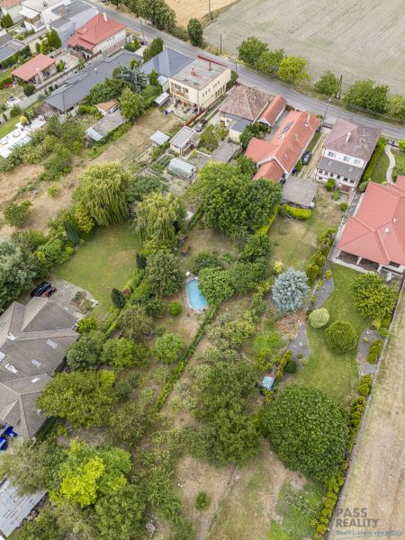 Gardens and family houses on Čigérska Street in Dunajská Streda, with a visible swimming pool.