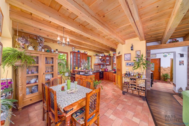 A kitchen and dining room in a family house with wooden ceilings and a floor with a wooden decor.