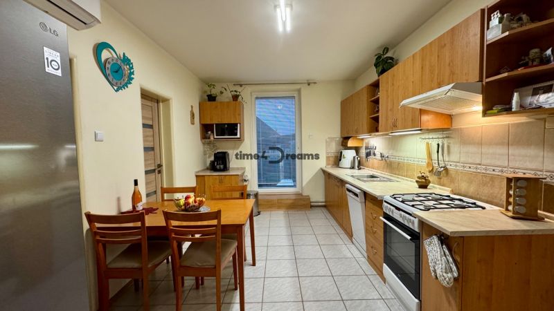 A kitchen in a family house with wooden decor furniture and a dining table.