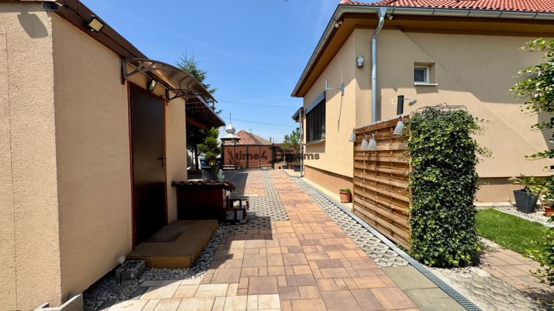 Paving in the courtyard of a family house in Čakajovce with wooden elements and greenery.
