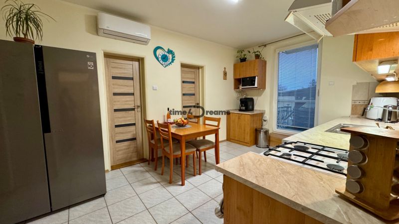 A kitchen in a family house with a dining area, a gas stove, and built-in appliances.