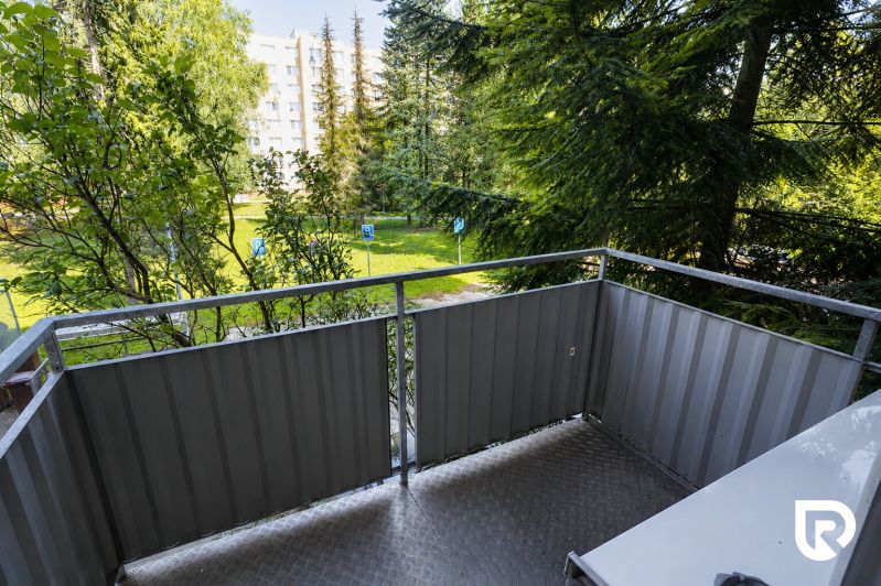 A balcony with a view of greenery, with residential buildings in the background, Žilina, Tulská 5.