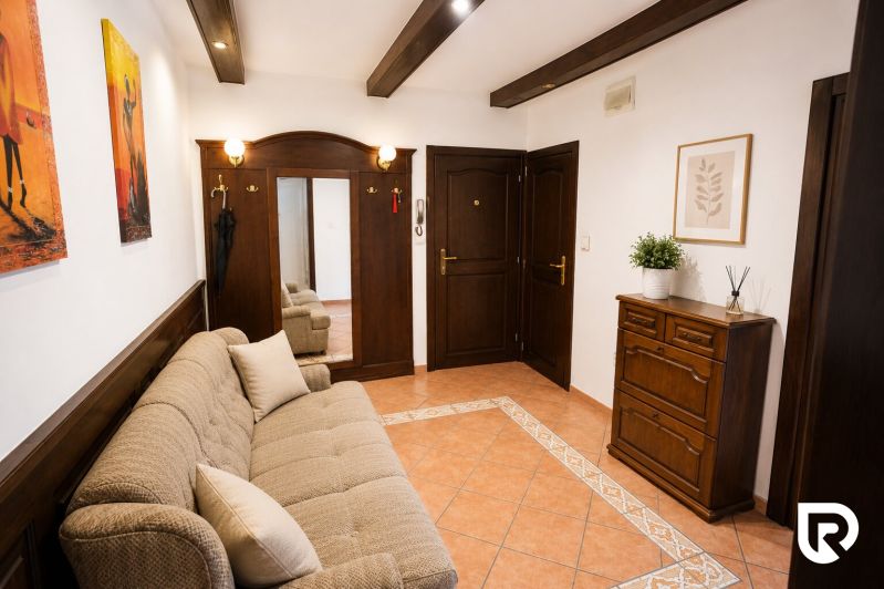 A comfortable hallway in a 2-room apartment with a mirror, sofa, and wooden furniture.