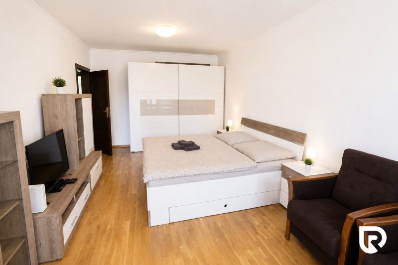 A bedroom in a 2-room apartment with furniture and flooring featuring a wood decor.