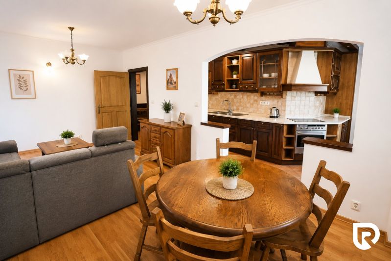 Living room with a kitchen and wooden decor in a 2-room apartment, with a dining table.