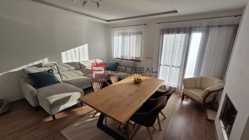 Living room of a family house with a corner sofa and a dining table.