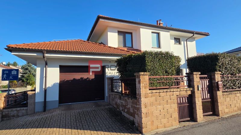 A family house on Pri Vápenickom potoku Street in Bratislava IV with a brick fence and a garage.