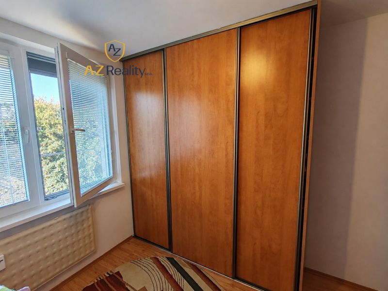 A wardrobe with sliding doors next to a window with a view in a 4-room apartment.