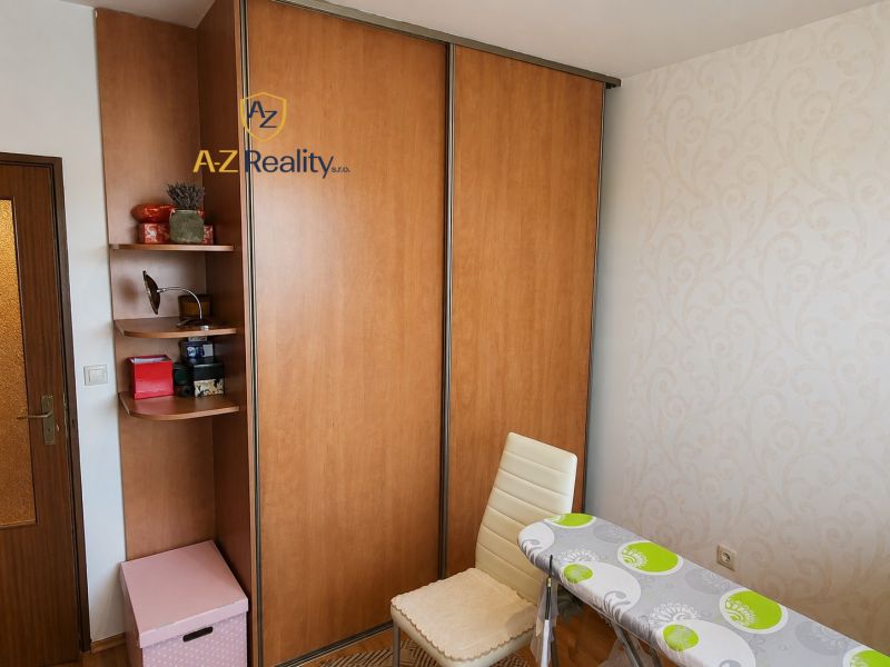 A room in a 4-room apartment with a sliding wardrobe, a chair, and an ironing board.