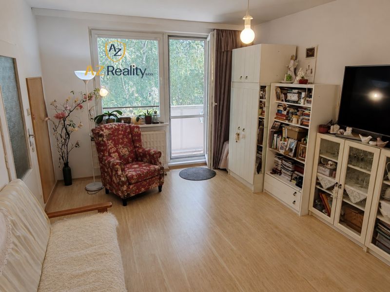 Living room in a four-room apartment with a wooden decor floor and a balcony.