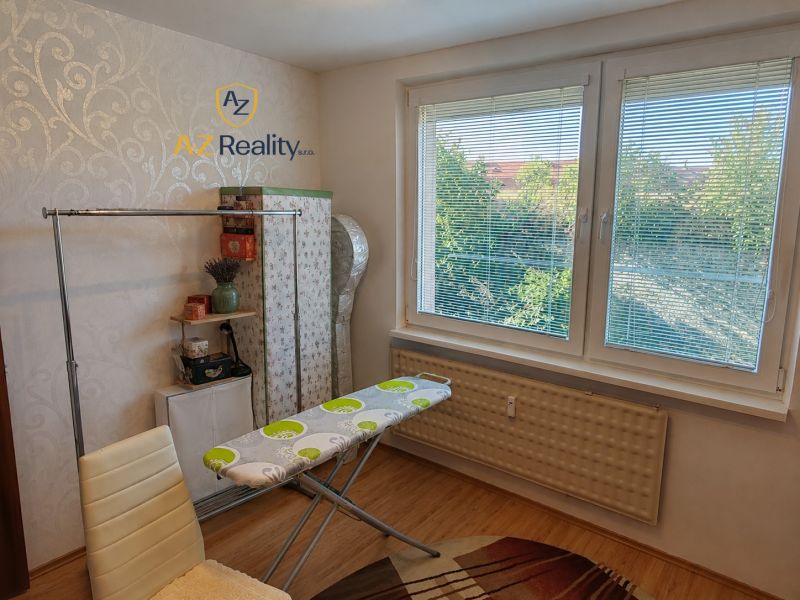 Ironing board in a four-room apartment with a wooden decor floor.