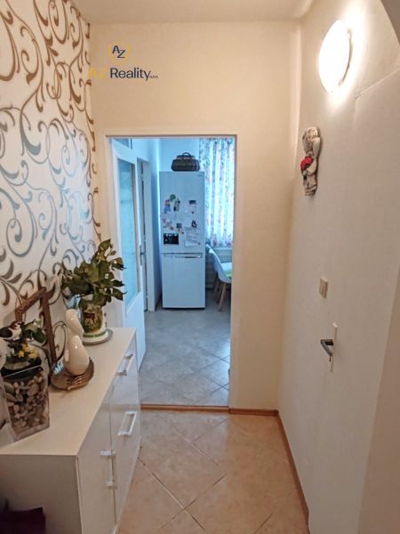 The hallway of a 4-room apartment with a decorative wall and entrance to the kitchen.