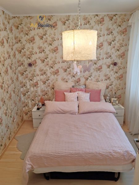 A bedroom with floral wallpaper and a wooden decor floor in a 4-room apartment.