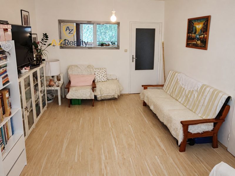 Living room with wood-patterned flooring in a 4-room apartment, bright and cozy furnishings.