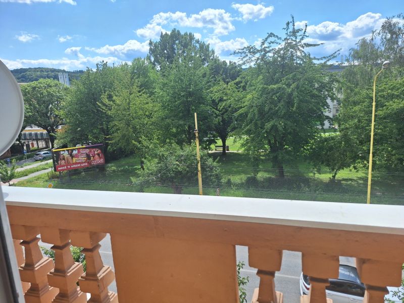 View from the balcony in Prešov on 17. novembra Street, overlooking greenery.