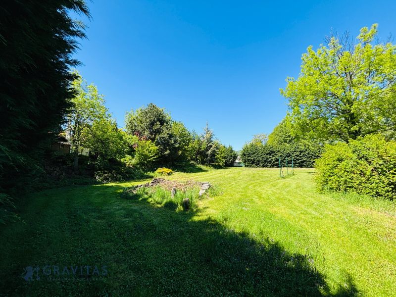 A landscaped green plot on Krátka Street in Limbach with numerous trees and shrubs.