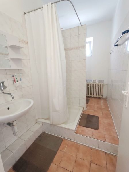 A bathroom in a family house with ceramic tiles and a shower enclosure.