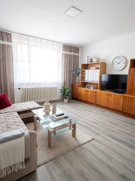 Living room with wood-decor flooring, glass table, and comfortable sofa.