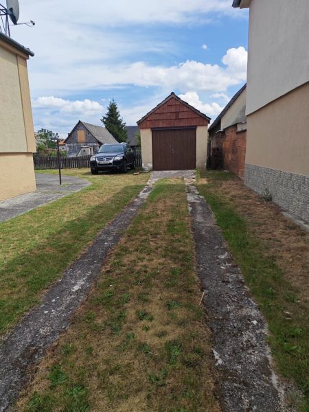 The courtyard of a family house in Lakšárska Nová Ves with a parked car and a garage.
