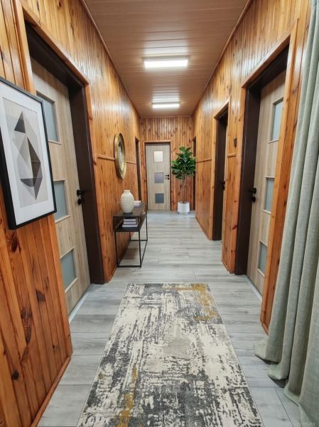 Interior of a family house with walls made of wooden panels and a floor with a wooden decor.