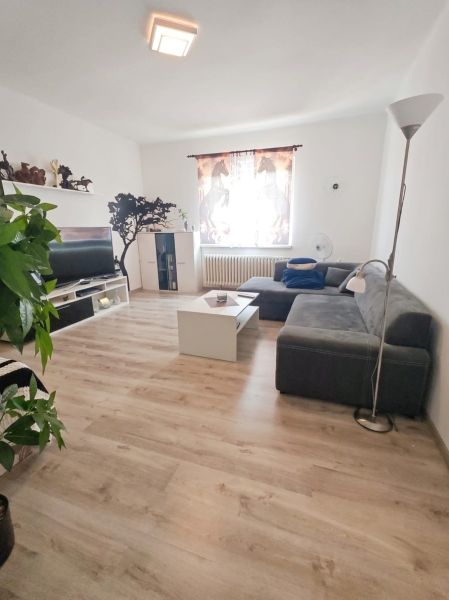 Living room in a family house with a wooden decor floor and a comfortable sofa.