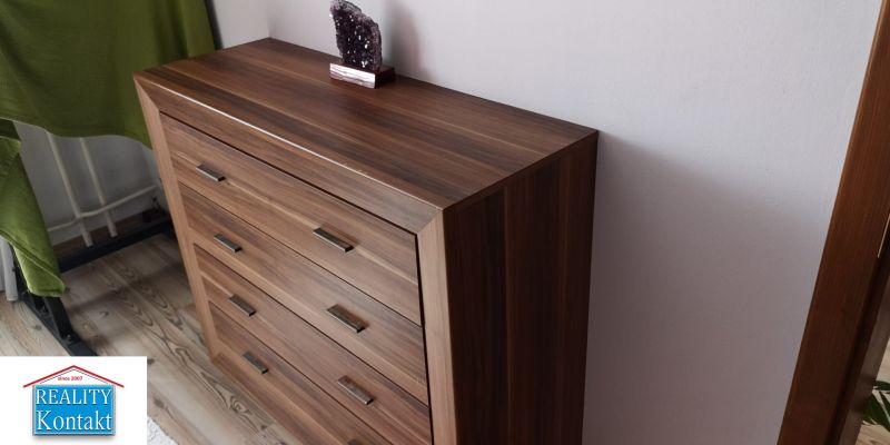 A dresser with a wooden floor decor in a studio apartment.