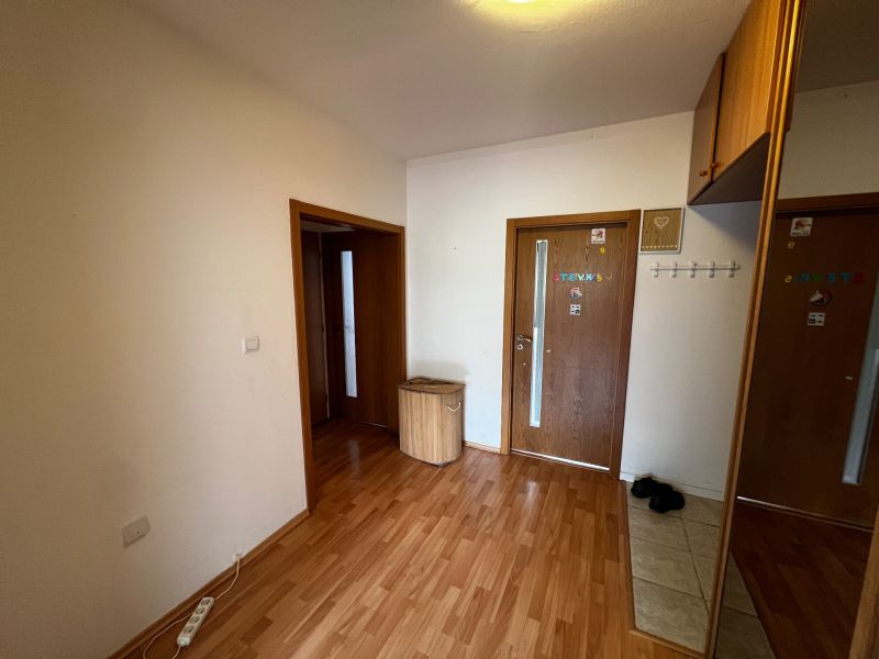 Entrance hall of a 3-room apartment with a wooden decor floor and a socket panel.