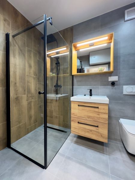 Stylish bathroom with a shower and a cabinet with a wooden decor.