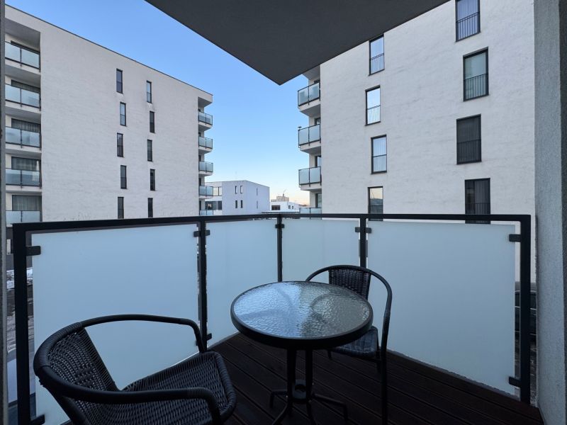 The balcony of a 2-room apartment on Jána Pavla II. in Prešov with furniture and a view of the buildings.