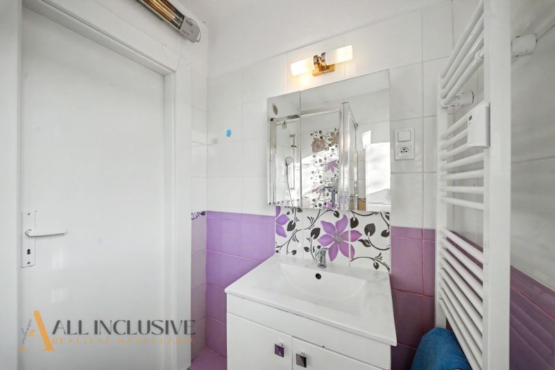 A bathroom in a 3-room apartment with floral tiles and white sanitary ware.