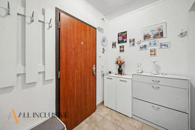 Entrance hall in a 3-room apartment with a coat rack and decorations on the walls.