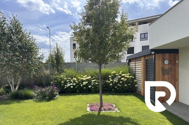 A garden at a family house on Rizlingova Street in Trenčín with a well-maintained lawn and trees.