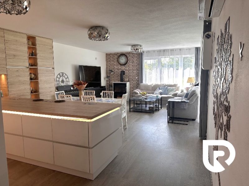 Living room with a kitchen island in a family house with a wooden decor floor.