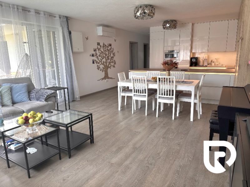 Living room of a family house with a wooden decor floor and a dining area.