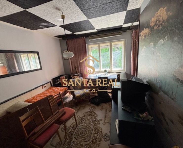 A room with carpet decor and a television in a family house.