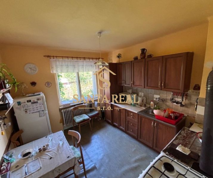 A kitchen in a family house with wooden decor on the kitchen unit and dining table.