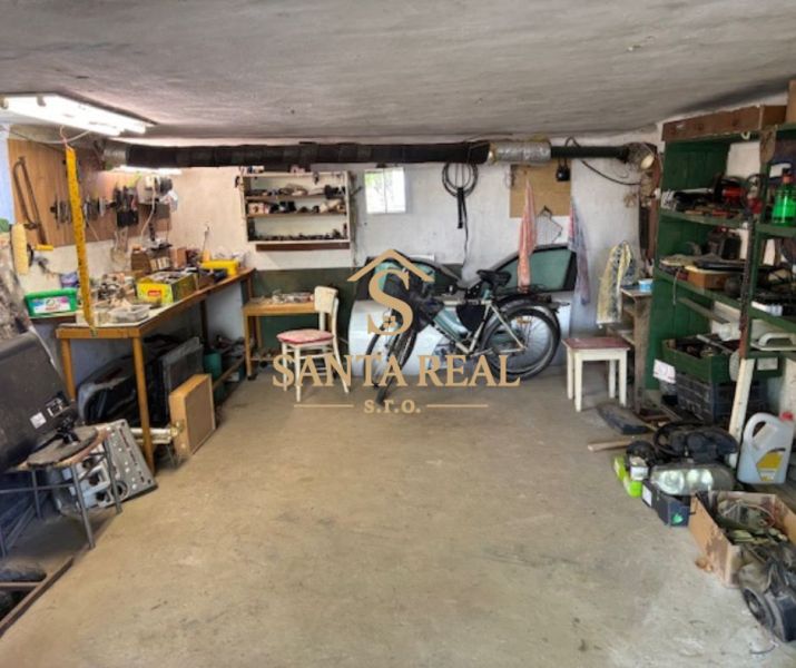 A garage with a workshop in a family house, equipped with workbenches and a bicycle.