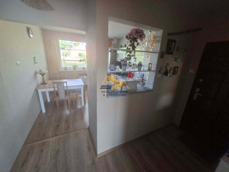 3-room apartment with a dining table, wooden decor flooring, bright kitchen.