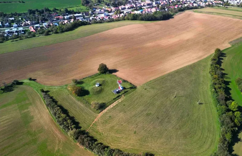 Aerial view of agricultural and forest land near Trenčianske Stankovce with a turret and trees.
