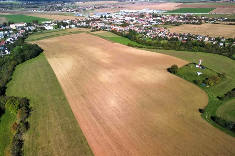 An aerial view of agricultural and forest lands in Trenčianske Stankovce with visible buildings.