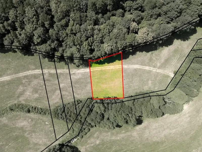 Aerial view of a fenced plot in the gardens of Horná Ves with surrounding trees.
