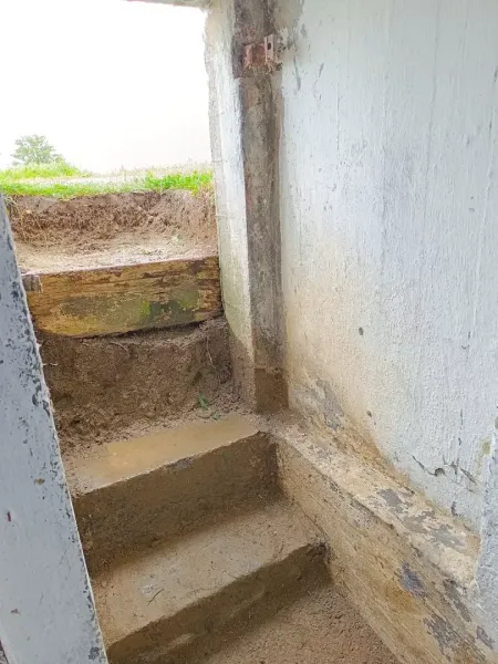 Stairs from the basement leading out of the property, surrounded by raw earth.