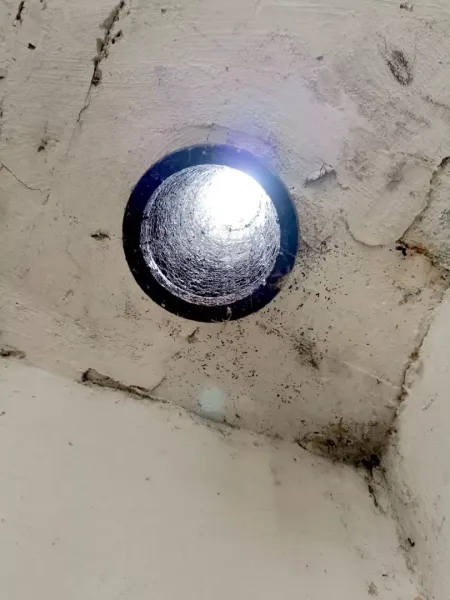 A ceiling opening with incoming light in Strange Properties, Malacky.