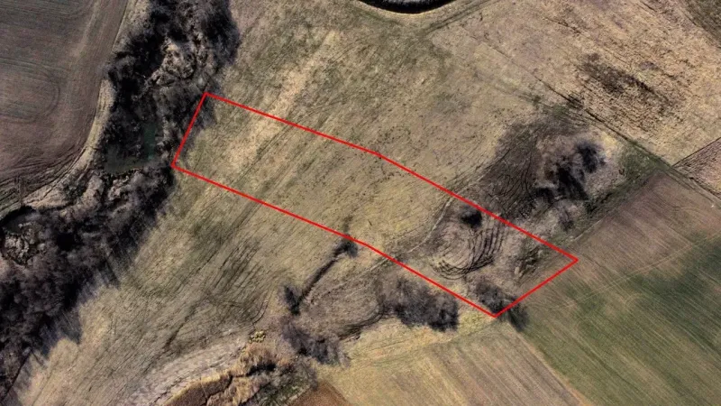 Aerial view of agricultural and forest land in Podhorany with a marked area.