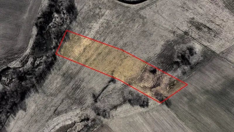 Aerial view of agricultural and forest land in Podhorany with marked area.